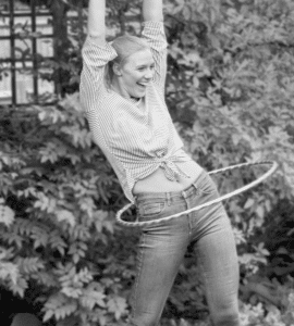 Glückliche Frau beim Hula-Hoop-Training im Freien, unterstützt durch Mutaflor® für eine gesunde Darmflora.