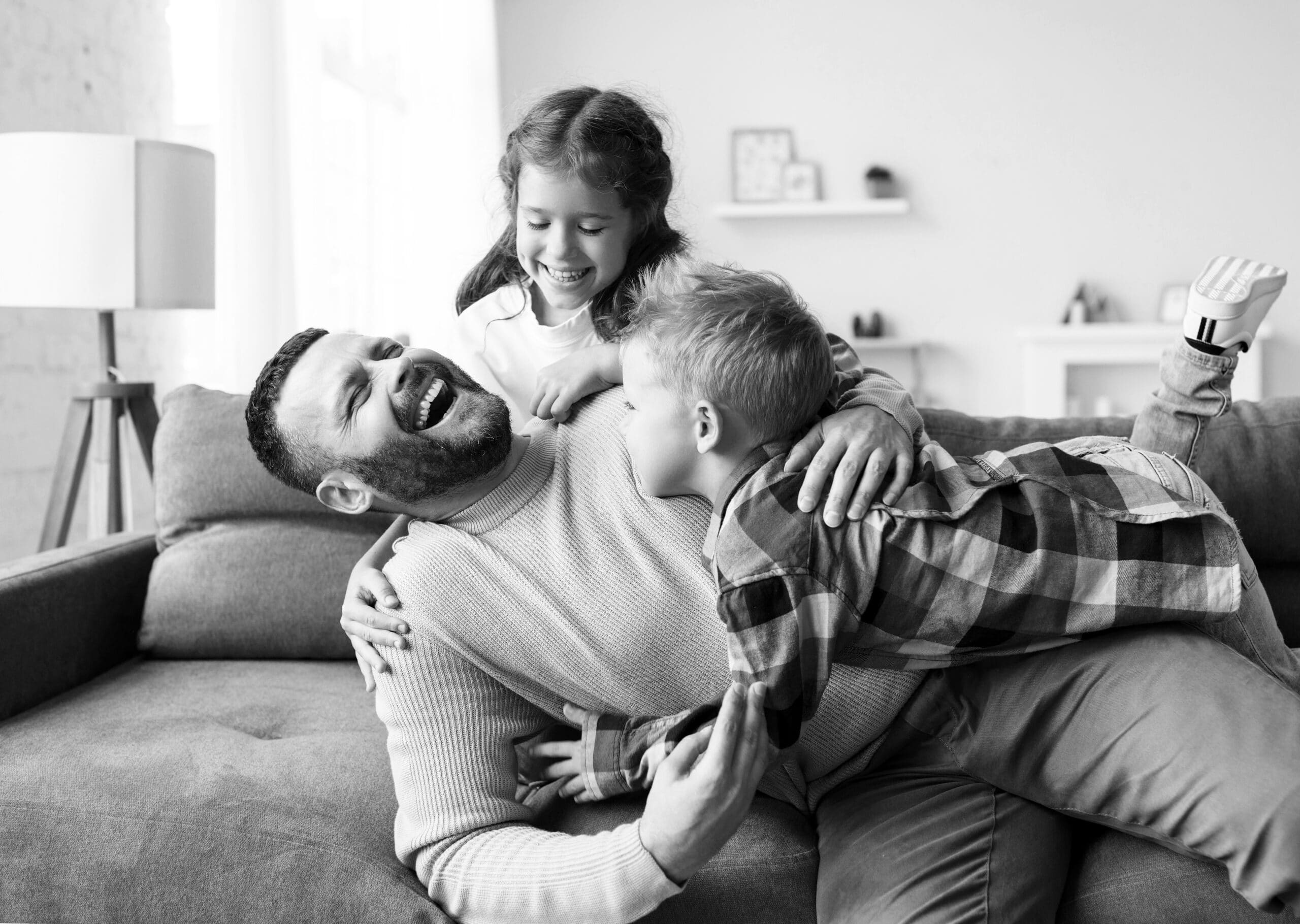 Vater tobt ausgelassen mit seinen zwei Kindern, die ihren Durchfall wieder losgeworden sind.