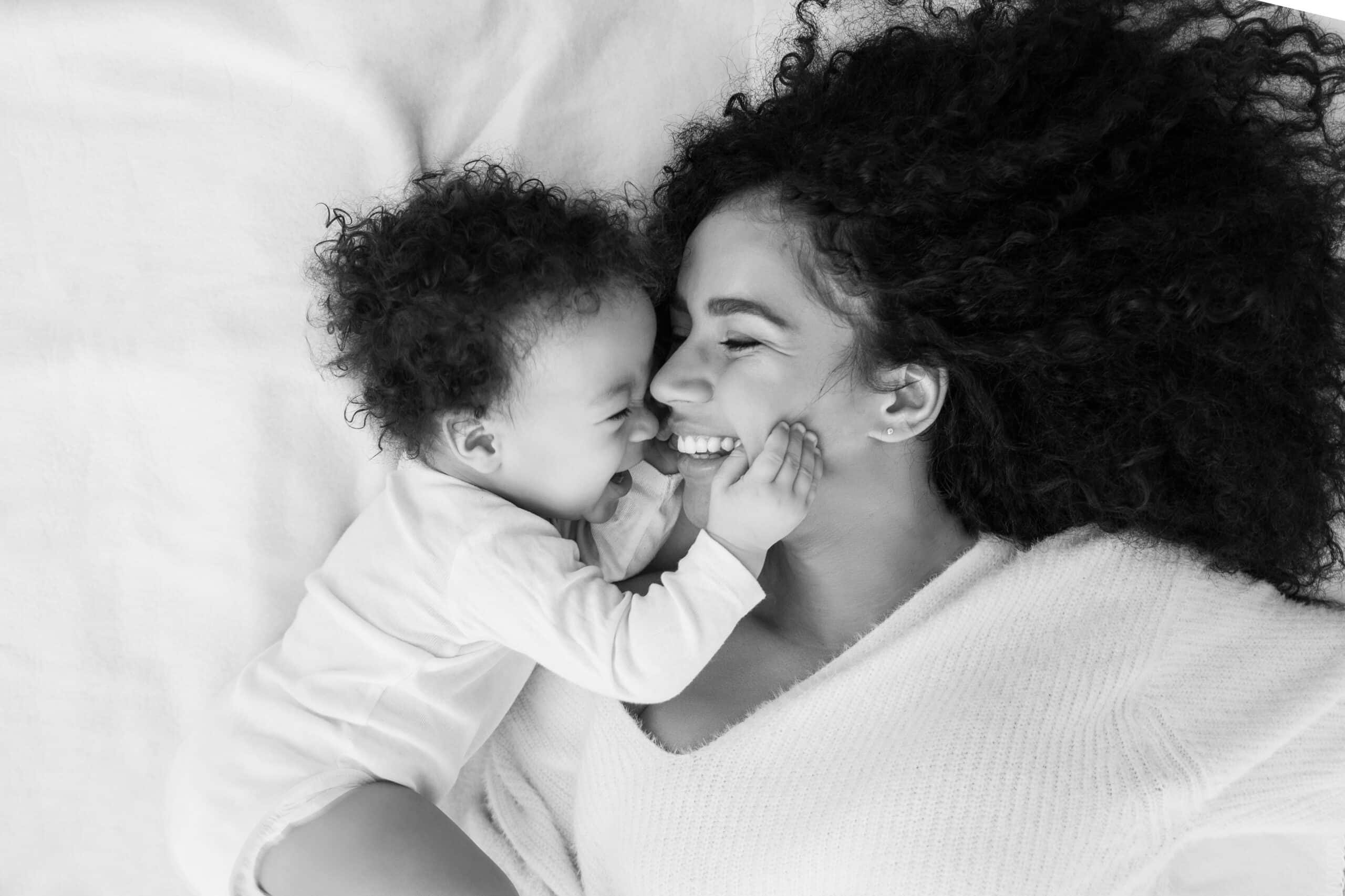 Den Durchfall im Griff: Mutter und Baby lachend im Bett.