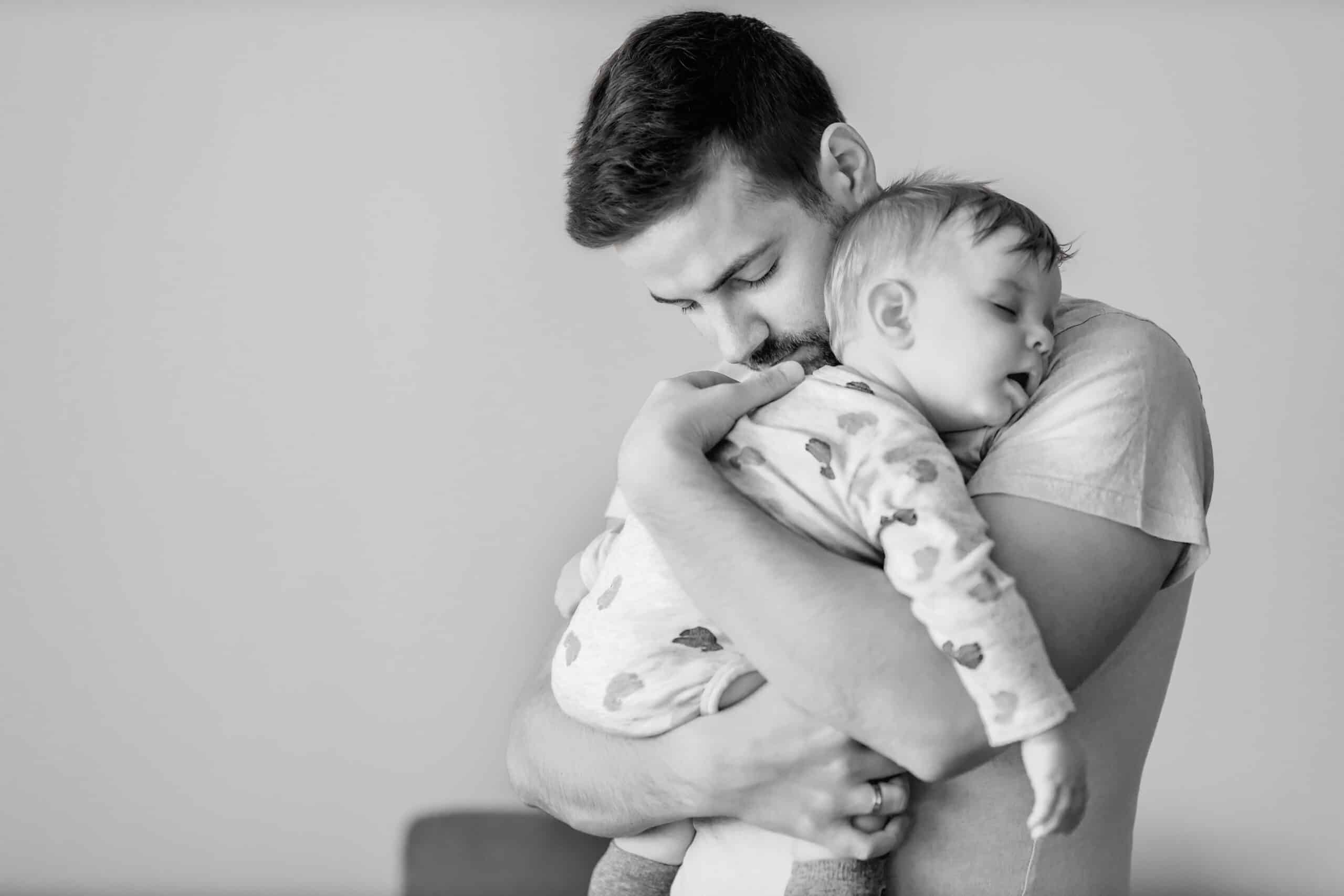 Vater hält sein vom Durchfall müdes Baby im Arm.