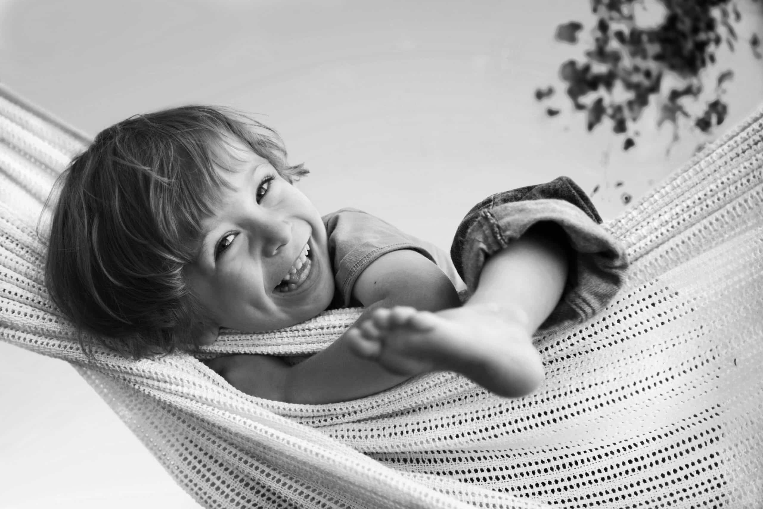 Kind lacht in Hängematte – entspannter Moment nach erfolgreichem Behandeln von Durchfall.
